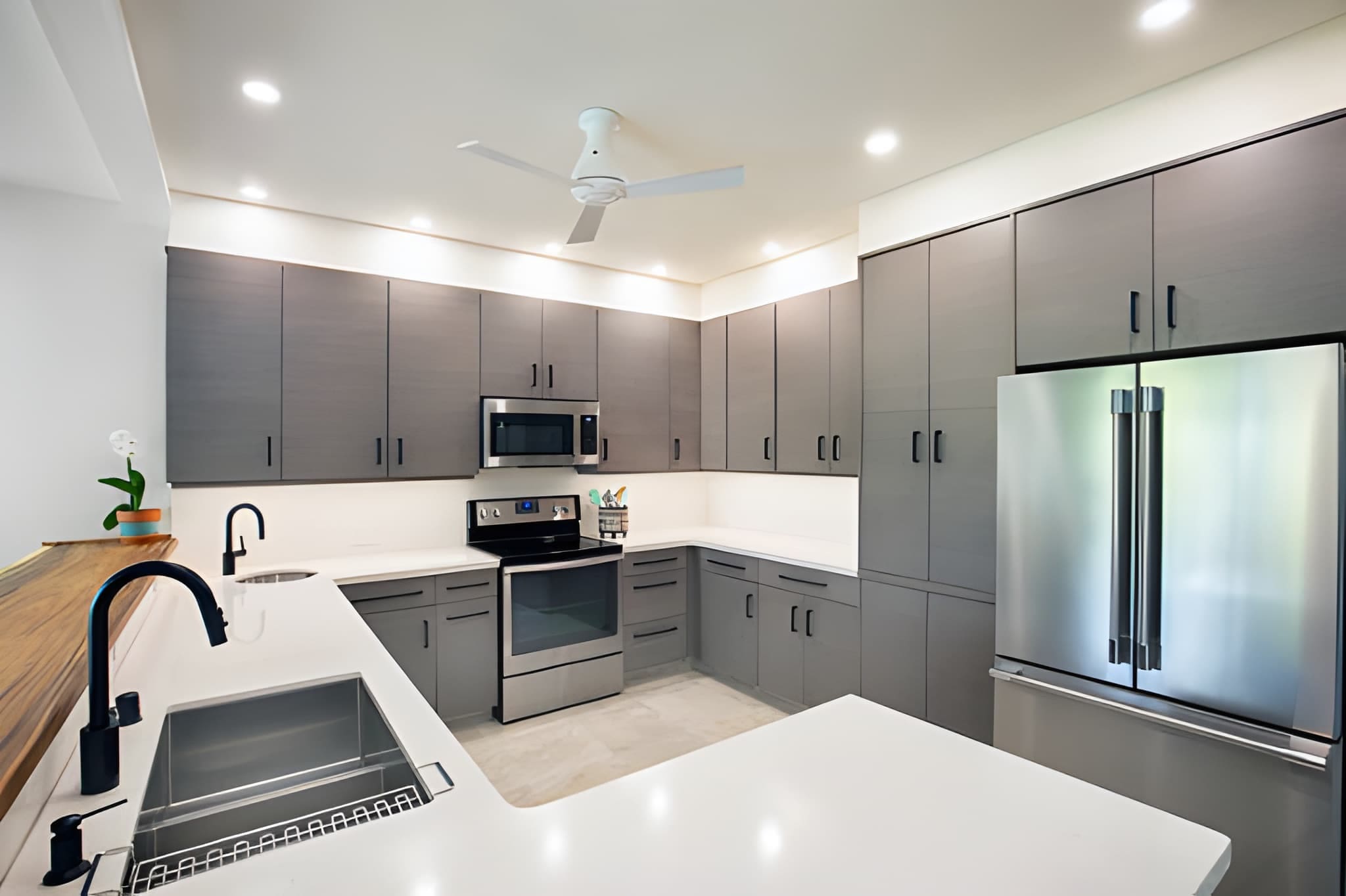 Kitchen remodeling Palm City FL—sleek modern kitchen with gray cabinets, white countertops, and stainless appliances.
