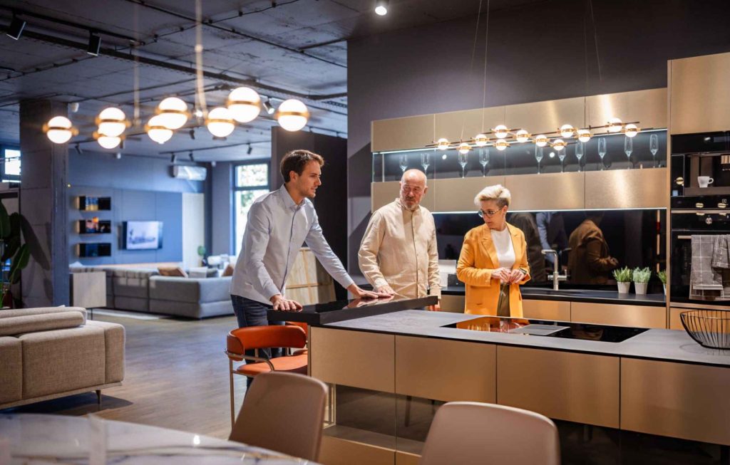 Kitchen renovation companies near me—modern showroom with island, cooktop, and stylish lighting.